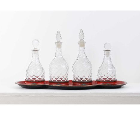 A Regency toleware tray and a set of glass decanters,early 19th century, of Pontypool type, comprising a red lobed tray with 