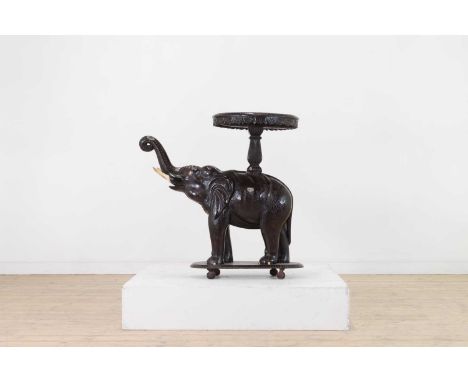 A painted hardwood elephant occasional table, late 19th/early 20th century, Indian, the circular top with carved foliate deta