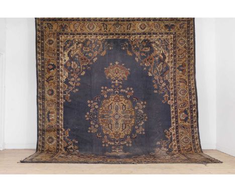 A wool carpet of Heriz design, 20th century, Anatolian, woven with geometric floral and foliate motifs, with an open field an