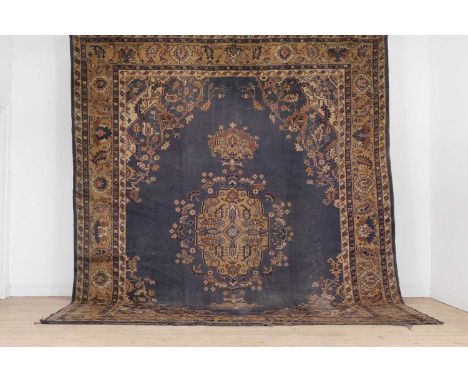 A wool carpet of Heriz design, 20th century, Anatolian, woven with geometric floral and foliate motifs, with an open field an