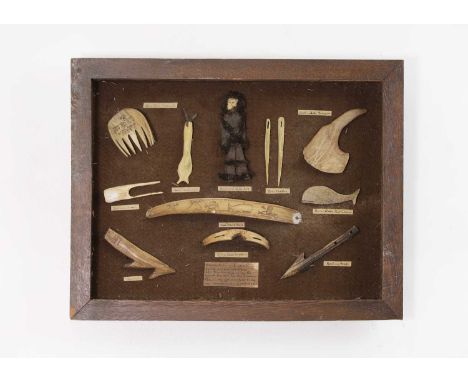 An oak-framed display of marine ivory, bone and antler 'tools and curios', 20th century, comprising ten mounted models with d