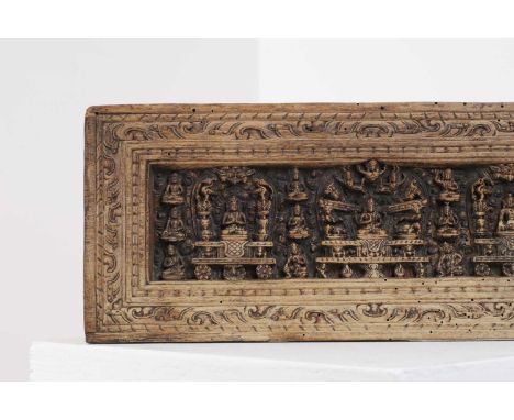 A carved wood manuscript cover,16th century or later, Tibetan, the rectangular recessed panel with Prajnaparamita in the cent