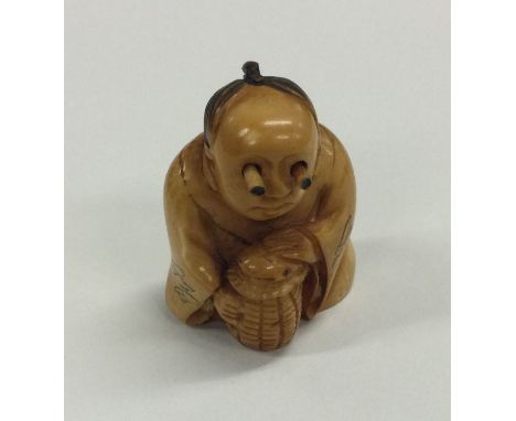 A carved ivory netsuke of a seated man. Est. £40 - £60.