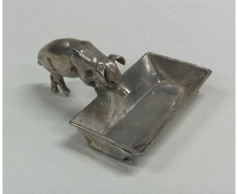 A novelty silver salt mounted with a pig eating from a trough. Chester. Approx. 13 grams. Est. £80 - £120.
