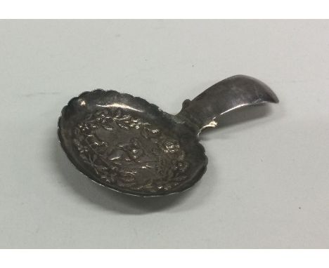 An unusual silver caddy spoon decorated with figures. Approx. 6 grams. Est. £30 - £50.