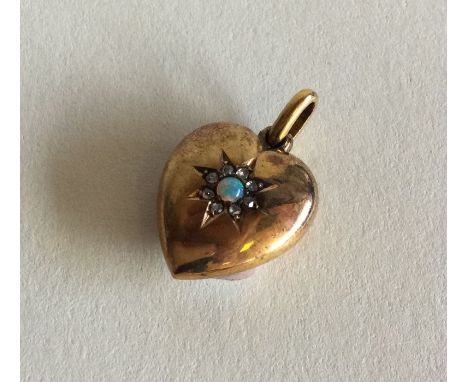 An attractive opal and diamond heart shaped pendant with loop top set in 15 carat gold. Approx. 2.5 grams. Est. £100 - £150.