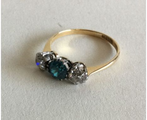 A diamond and zircon three stone ring in two colour 18 carat gold claw mount. Approx. 2 grams. Est. £80 - £120.