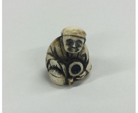 A carved ivory netsuke of a seated man. Est. £40 - £60.