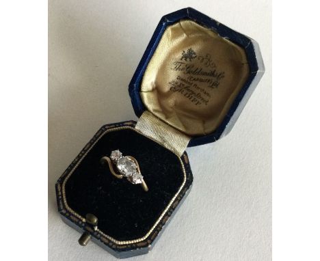 A large diamond three stone crossover ring in two colour claw mount. Approx. 4 grams. Est. £120 - £150.