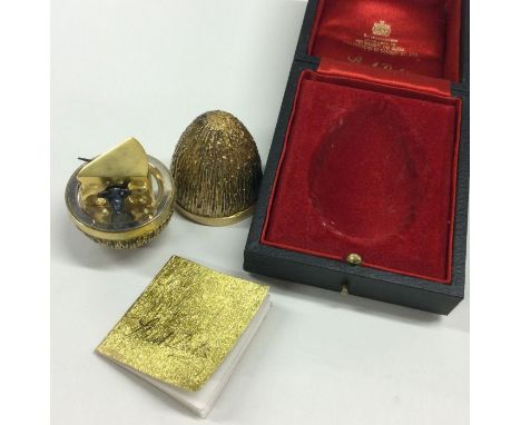 STUART DEVLIN: A heavy novelty silver gilt egg decorated with a mouse eating cheese, contained within a fitted box. London 19