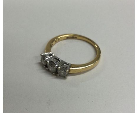 A diamond three stone ring in two colour 18 carat gold and platinum claw mount. Approx. 4 grams. Est. £100 - £150.