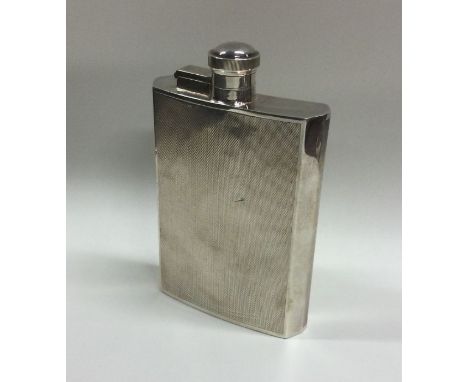 A heavy engine turned silver hip flask of shaped form. London. By JD&amp;S. Approx. 173 grams. Est. £150 - £200.