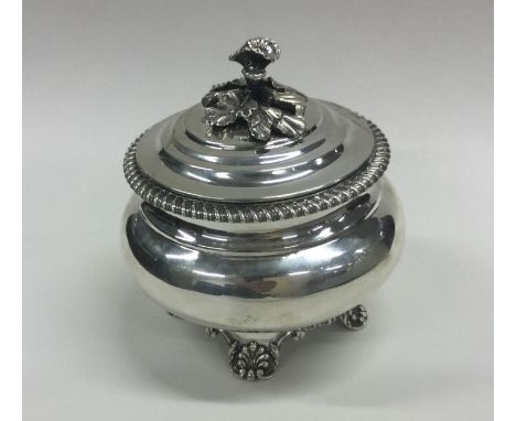 A William IV cylindrical silver tea caddy with gadroon rim and floral thumb piece to scroll feet. London 1837. By Richard Pie