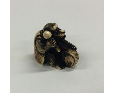 A small carved ivory netsuke in the form of a monkey. Approx. 25 grams. Est. £45 - £50.