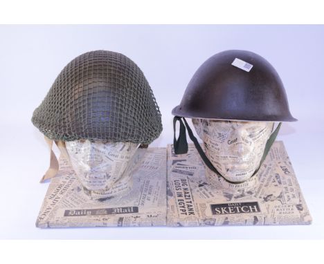 Two British army turtle helmets, green and black, with five display heads covered in wartime newspaper Condition Report Click