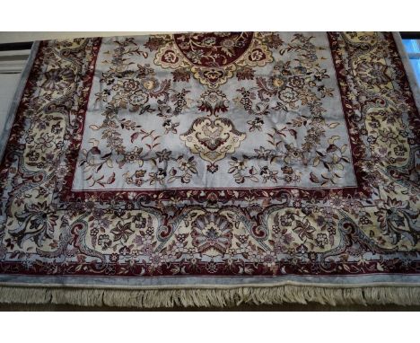 A Tabriz carpet On a mainly blue ground, the central oval medallion, flanked by two florally decorated medallions, complete w