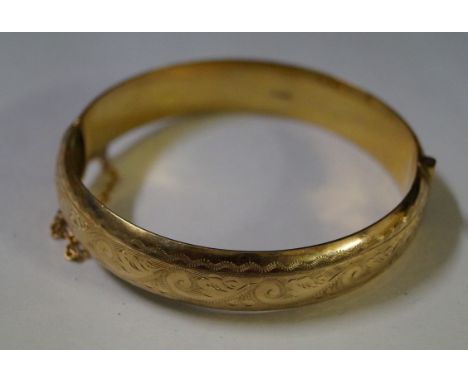 A 9ct gold hinged bangle, with engraved decoration, weight 15.9g 