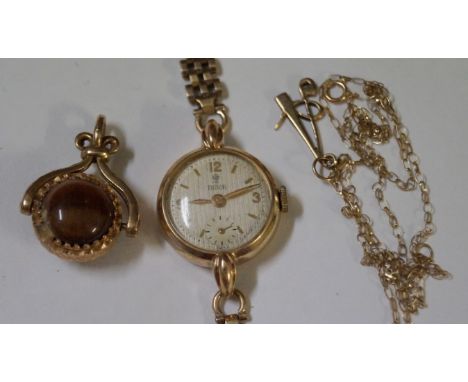 Tudor: A Ladies 9ct gold manual wind bracelet watch, together with, a 9ct gold Tiger's eye spinning fob, a 9ct gold 'A' penda