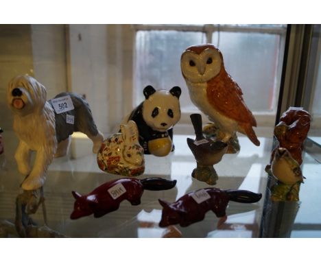A group of ceramic animal figures to include two Royal Doulton flambe foxes, a Royal Crown Derby meadow rabbit, a Beswick mod