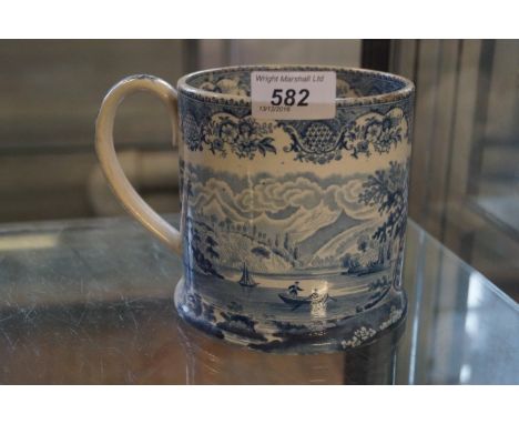 A late 19th Century blue and white ceramic tankard depicting scenes of a rowing boat in river landscape.