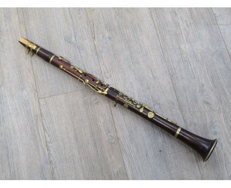 An early 20th Century rosewood clarinet with brass fittings, makers name indistinct