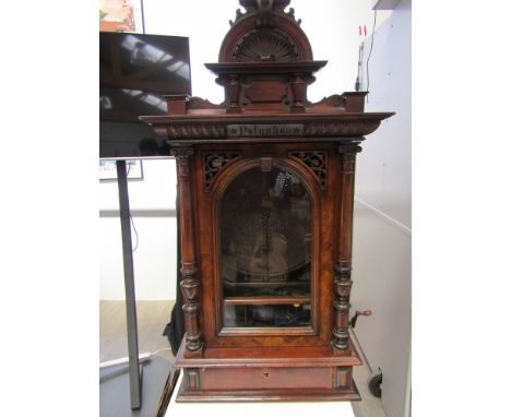 A Victorian Polyphon with walnut case, the moulded cornice over ''Polyphon'' carved panel to central domed glass door flanked