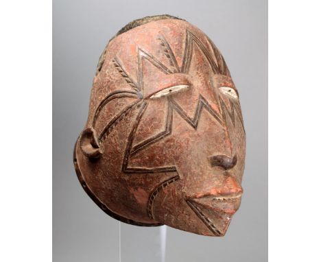 A Makonde helmet mask Mozambique wood with raised scarifications and the top with a shaped panel of applied hair, with an enc