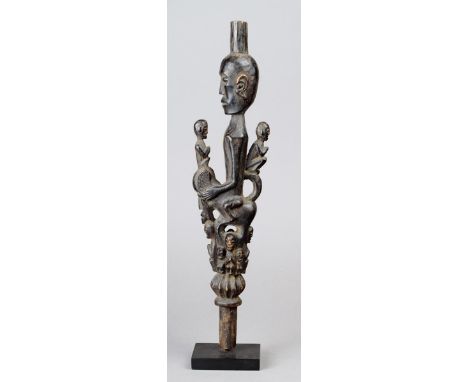 A Batak staff finial Indonesia wood with an ancestor figure riding a beast, surrounded by other figures, 30.5cm high on a sta