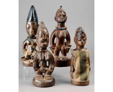Four Yoruba Ibeji figures Nigeria wood, including a female with carved zig-zags on her breasts and wearing beads, another wit