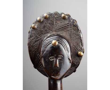 An Ovimbundu staff Angola wood, with a carved head finial with an ovoid coiffure with geometric decoration and a raised back,
