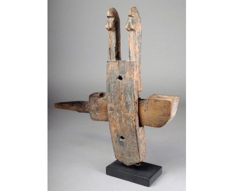 A Dogon door lock Mali wood with twin figural finials and incised decoration, 37cm high, on a stand. (3) Provenance Ian Auld,