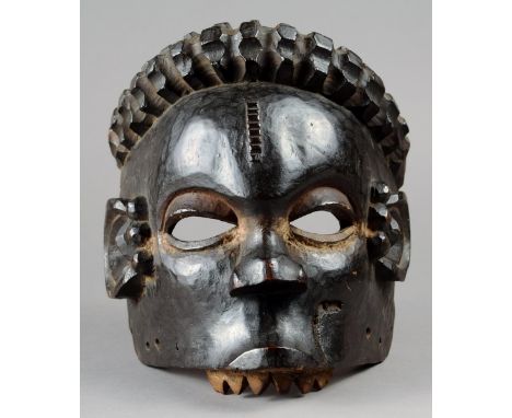 A Ibibio mask Nigeria wood, with a black patina and white highlights, lower jaw missing, 21.5cm high. Provenance The David Mo