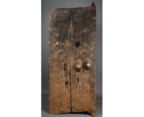 A Dogon door Mali wood, one panel carved a pair of breasts, 145.5cm high, 58cm wide. Provenance Seward Kennedy, London.