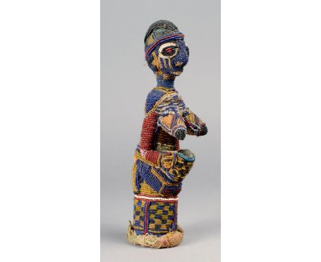 A Yoruba kneeling female offering figure Nigeria beadwork and cloth, 27.5cm high. Provenance The David Morris Collection. Ian