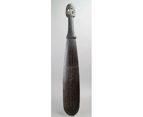 A Massim club Trobriand Islands, Papua New Guinea palmwood with a concave blade, incised scroll and zig-zag decoration and wi