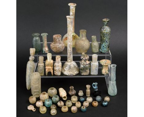 A collection of glass vessels including an Islamic molar flask, a Roman unguentarium, a faceted globular vessel, a miniature 