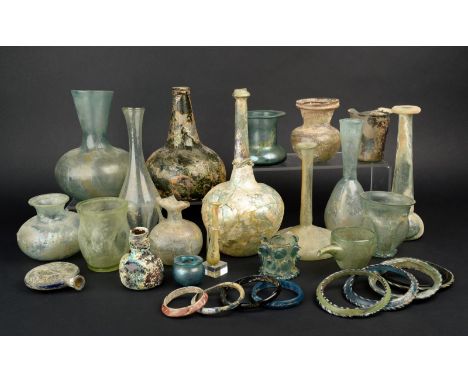 A collection of Roman and later glass vessels including three beakers, a moon flask, a feeding cup, three slender neck jars, 