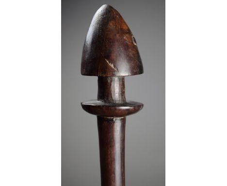A Vanuatu club Melanesia wood with a conical finial above a flange, the shaft with a flared base, 94cm long.