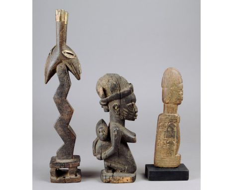 A Yoruba kneeling maternity figure Nigeria wood, with various items in her head band and with a child, 22.5cm high, a Bambara