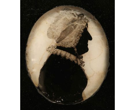 * Silhouette. Portrait of an older woman, early 19th century, reverse painting on convex glass, oval silhouette showing head 