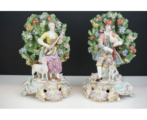 Pair of Chelsea Porcelain Bocage Figures in the form of a Man playing bagpipes with a dog and a Woman playing a lute with a s