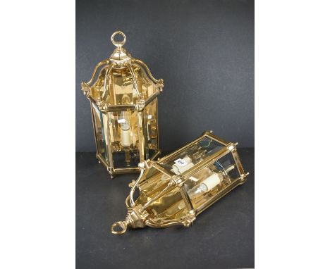 A pair of heavy gauge gilt brass wall lights in the George III style with three bevelled glass panels to each lamp. 