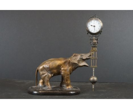 Early 20th century Cast Metal Elephant Mystery Clock, the trunk holding a Junghans Clock and three rod pendulum, 27cm high 