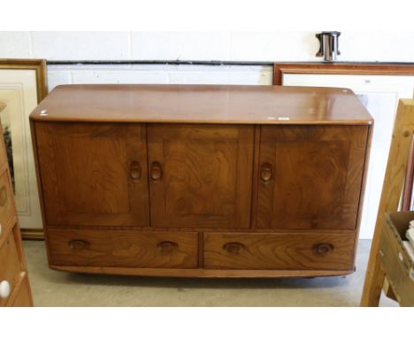 Ercol ' Windsor ' Light Elm Sideboard with three cupboard doors over two drawers, with oval handles and raised on castors, 12