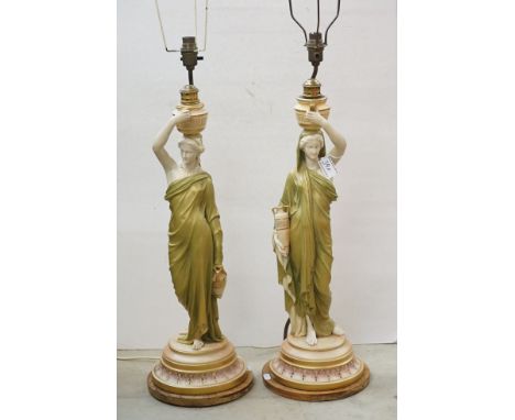 Pair of Royal Worcester ' Cricklite ' stem Figural Table Lamps in the form of Water Carriers raised on wooden bases, 57cm to 