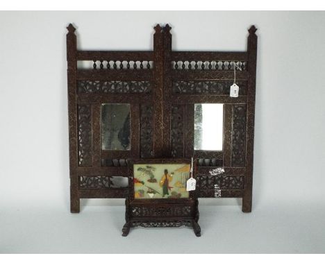 An Asian two panel folding screen, intricately carved with inset mirrors, 64 cm x 63 cm and a Chinese carved wood table scree