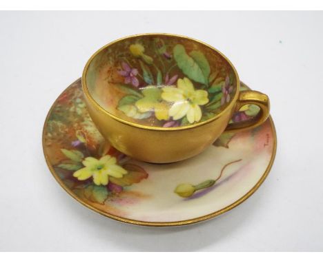 A Royal Worcester porcelain miniature cup and saucer with floral decoration to the interior and gilt exterior, printed marks 