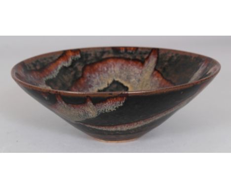 A CHINESE JIZHOU GLAZED CONICAL CERAMIC BOWL, decorated with an irregular design, the base unglazed, 6.4in diameter & 2.2in h