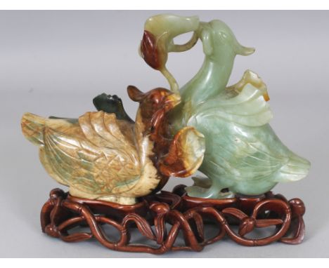 A GOOD QUALITY 20TH CENTURY CHINESE JADE MODEL OF TWO DUCKS, together with a fitted wood stand, the ducks grasping a frond of