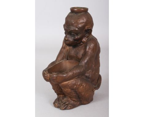 AN EARLY 20TH CENTURY JAPANESE BRONZED CERAMIC MODEL OF A MONKEY, squatting and holding a bowl, 6.75in high.